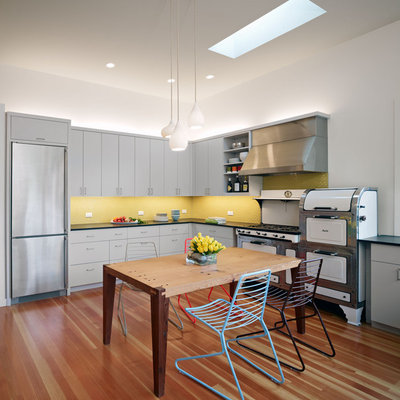 Example of a large trendy u-shaped eat-in kitchen design in San Francisco with white appliances, yellow backsplash, flat-panel cabinets, gray cabinets, mosaic tile backsplash, an undermount sink and no island