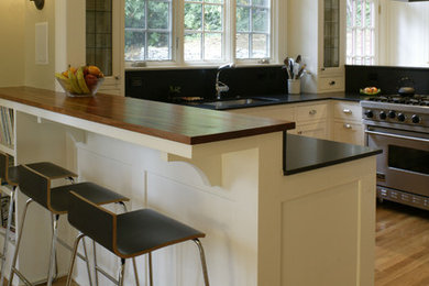 Example of a mid-sized classic u-shaped light wood floor eat-in kitchen design in Portland with an undermount sink, shaker cabinets, white cabinets, granite countertops, stainless steel appliances and a peninsula