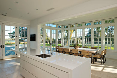 Идея дизайна: угловая кухня среднего размера в классическом стиле с обеденным столом, врезной мойкой, плоскими фасадами, белыми фасадами, техникой из нержавеющей стали, полом из керамической плитки и островом