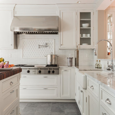 Elegant slate floor and gray floor kitchen photo in Boston with a farmhouse sink, recessed-panel cabinets, white cabinets, white backsplash and stainless steel appliances
