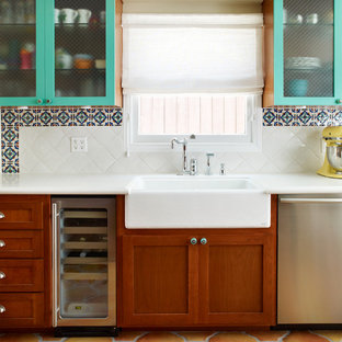 Tuscan kitchen photo in Los Angeles with a farmhouse sink, glass-front cabinets, quartz countertops, multicolored backsplash, stainless steel appliances and dark wood cabinets