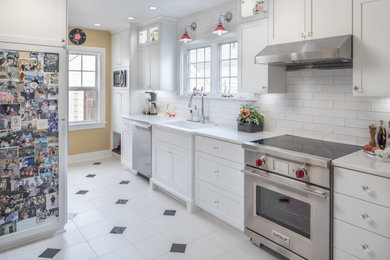 Eat-in kitchen - small transitional galley ceramic tile and white floor eat-in kitchen idea in Portland with a farmhouse sink, recessed-panel cabinets, white cabinets, marble countertops, white backsplash, subway tile backsplash, stainless steel appliances, a peninsula and white countertops