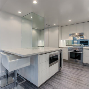 Inspiration for a mid-sized modern l-shaped eat-in kitchen in Los Angeles with a drop-in sink, louvered cabinets, stainless steel appliances and vinyl floors.