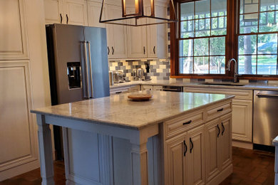 Large elegant u-shaped brick floor, multicolored floor and tray ceiling kitchen pantry photo in Orlando with an undermount sink, raised-panel cabinets, white cabinets, quartz countertops, multicolored backsplash, subway tile backsplash, stainless steel appliances, an island and multicolored countertops