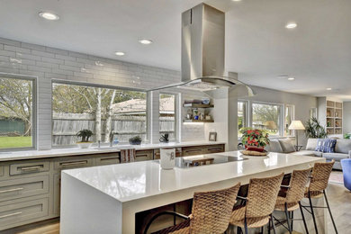 Bild på ett funkis vit vitt kök, med skåp i shakerstil, grå skåp, bänkskiva i kvartsit, vitt stänkskydd, stänkskydd i keramik, rostfria vitvaror och en köksö