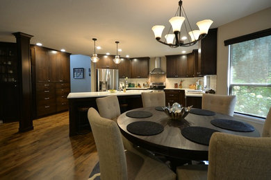 Mid-sized elegant l-shaped light wood floor eat-in kitchen photo in Boise with a double-bowl sink, recessed-panel cabinets, dark wood cabinets, quartzite countertops, white backsplash, subway tile backsplash, stainless steel appliances and an island
