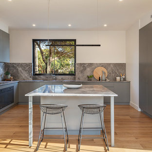 Design ideas for a mid-sized contemporary l-shaped kitchen in Melbourne with flat-panel cabinets, grey cabinets, grey splashback, stone slab splashback, light hardwood floors, with island and grey benchtop.