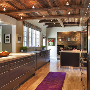 Inspiration for a large country u-shaped kitchen in New York with stainless steel appliances, an integrated sink, flat-panel cabinets, medium wood cabinets, concrete benchtops, travertine floors and multiple islands.