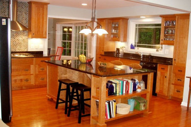 Example of a large eclectic u-shaped light wood floor kitchen design in DC Metro with shaker cabinets, medium tone wood cabinets, granite countertops, multicolored backsplash and an island