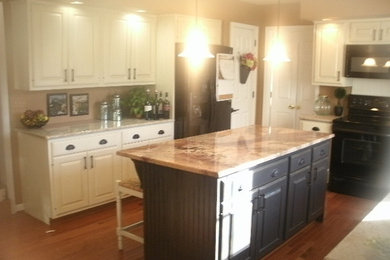 フィラデルフィアにあるおしゃれなキッチン (白いキャビネット、ベージュキッチンパネル、黒い調理設備、無垢フローリング) の写真