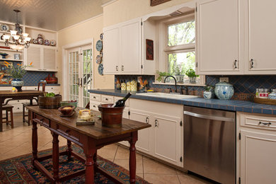 ダラスにあるトラディショナルスタイルのおしゃれなキッチン (シルバーの調理設備、タイルカウンター、青いキッチンパネル) の写真