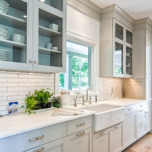 Mid-sized farmhouse eat-in kitchen ideas - Eat-in kitchen - mid-sized country single-wall light wood floor eat-in kitchen idea in New York with an undermount sink, shaker cabinets, white cabinets, granite countertops, white backsplash, subway tile backsplash, stainless steel appliances and an island