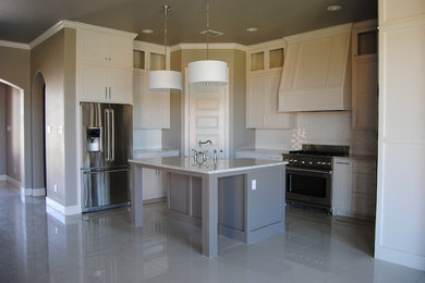 Example of a mid-sized trendy u-shaped porcelain tile enclosed kitchen design in Austin with a farmhouse sink, shaker cabinets, white cabinets, quartz countertops, white backsplash, ceramic backsplash, stainless steel appliances and an island