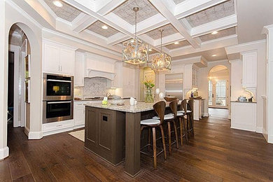 Example of a large trendy l-shaped dark wood floor eat-in kitchen design in Richmond with raised-panel cabinets, white cabinets, gray backsplash, stainless steel appliances and an island