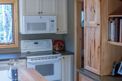 Example of a mid-sized mountain style l-shaped light wood floor and brown floor eat-in kitchen design in Toronto with recessed-panel cabinets, white cabinets, wood countertops, an island and brown countertops