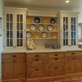 This is an example of a large country l-shaped separate kitchen in San Luis Obispo with a farmhouse sink, beaded inset cabinets, white cabinets, limestone benchtops, white splashback, stone tile splashback, stainless steel appliances, terra-cotta floors and with island.