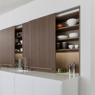 Inspiration för mellanstora moderna kök med öppen planlösning, med släta luckor, skåp i mörkt trä, bänkskiva i kvartsit, rostfria vitvaror, en köksö, en integrerad diskho och betonggolv
