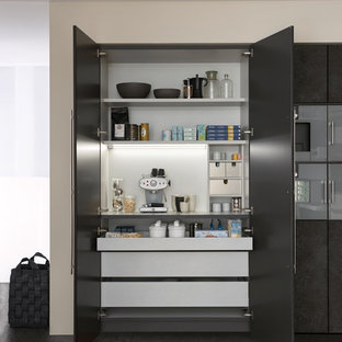 Ispirazione per una cucina minimalista di medie dimensioni con lavello da incasso, ante lisce, ante grigie, top in superficie solida, paraspruzzi bianco, elettrodomestici in acciaio inossidabile, pavimento in cemento e isola