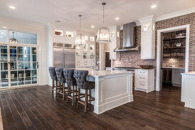 Kitchen - large transitional l-shaped medium tone wood floor and brown floor kitchen idea in Columbus with an undermount sink, recessed-panel cabinets, white cabinets, quartz countertops, brown backsplash, brick backsplash, stainless steel appliances and an island
