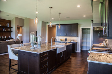 Transitional l-shaped dark wood floor and brown floor eat-in kitchen photo in Other with a farmhouse sink, shaker cabinets, dark wood cabinets, granite countertops, beige backsplash, glass tile backsplash, stainless steel appliances and an island