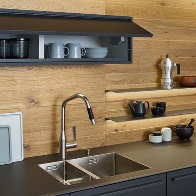 Eat-in kitchen - large modern single-wall concrete floor eat-in kitchen idea in New York with a double-bowl sink, flat-panel cabinets, gray cabinets, solid surface countertops, brown backsplash, stainless steel appliances and an island