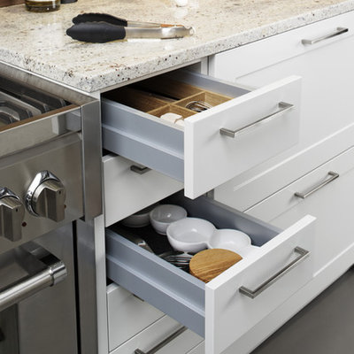 Eat-in kitchen - large modern l-shaped concrete floor eat-in kitchen idea in New York with a farmhouse sink, shaker cabinets, white cabinets, laminate countertops, brown backsplash, stainless steel appliances and a peninsula