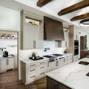 Foto di un'ampia cucina minimalista con lavello sottopiano, ante lisce, ante in legno chiaro, paraspruzzi bianco, paraspruzzi in marmo, elettrodomestici in acciaio inossidabile, isola, pavimento marrone, top in quarzite, parquet scuro e top bianco