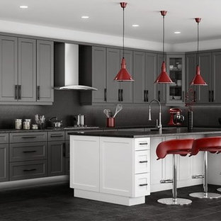Mid-sized contemporary galley open plan kitchen in Other with ceramic splashback, with island, a double-bowl sink, raised-panel cabinets, blue cabinets, green splashback, vinyl floors, solid surface benchtops, stainless steel appliances and black floor.