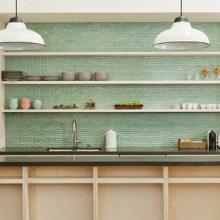 Mid-sized contemporary open concept kitchen inspiration - Open concept kitchen - mid-sized contemporary galley beige floor open concept kitchen idea in Other with a double-bowl sink, flat-panel cabinets, green backsplash, ceramic backsplash, an island, beige cabinets, solid surface countertops and stainless steel appliances