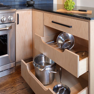 Mid-sized modern eat-in kitchen appliance - Mid-sized minimalist l-shaped medium tone wood floor and brown floor eat-in kitchen photo in San Francisco with an undermount sink, flat-panel cabinets, light wood cabinets, granite countertops, blue backsplash, ceramic backsplash, stainless steel appliances, a peninsula and black countertops