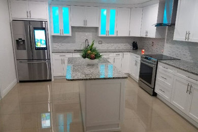 Large minimalist galley cement tile floor and brown floor eat-in kitchen photo in Tampa with a double-bowl sink, flat-panel cabinets, white cabinets, granite countertops, multicolored backsplash, cement tile backsplash, stainless steel appliances, an island and gray countertops