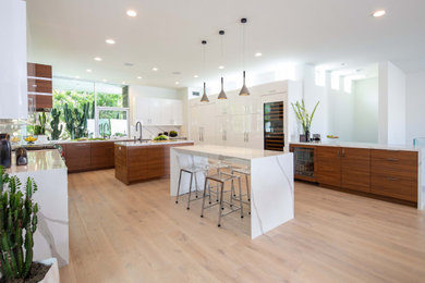 Inspiration for a large contemporary u-shaped light wood floor eat-in kitchen remodel in Orange County with flat-panel cabinets, quartz countertops, an island and white countertops