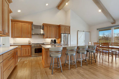 Inspiration for a mid-sized craftsman l-shaped light wood floor and brown floor open concept kitchen remodel in Other with an undermount sink, recessed-panel cabinets, light wood cabinets, granite countertops, stainless steel appliances, an island and multicolored countertops