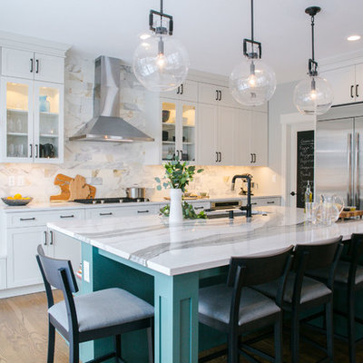 Inspiration for a large transitional brown floor and dark wood floor kitchen remodel in Denver with an undermount sink, shaker cabinets, white cabinets, quartz countertops, marble backsplash, stainless steel appliances, an island, white countertops and white backsplash