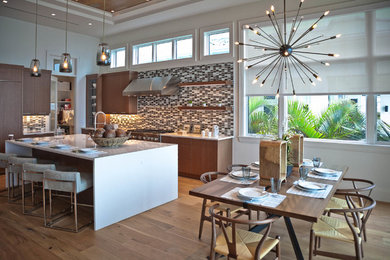 Eat-in kitchen - mid-sized l-shaped dark wood floor and brown floor eat-in kitchen idea in Phoenix with flat-panel cabinets, brown cabinets, solid surface countertops, multicolored backsplash, mosaic tile backsplash, stainless steel appliances and an island