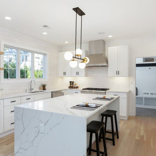 Transitional kitchen photos - Kitchen - transitional u-shaped light wood floor and beige floor kitchen idea in New York with an undermount sink, shaker cabinets, white cabinets, white backsplash, stainless steel appliances, an island and white countertops