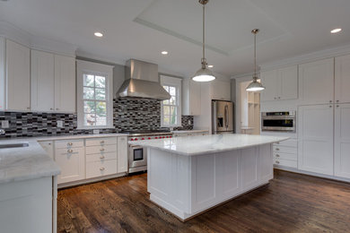Large transitional u-shaped dark wood floor and brown floor enclosed kitchen photo in DC Metro with an undermount sink, shaker cabinets, white cabinets, quartzite countertops, gray backsplash, glass tile backsplash, stainless steel appliances, an island and white countertops