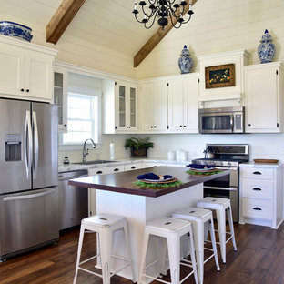Mid-sized farmhouse kitchen designs - Inspiration for a mid-sized farmhouse l-shaped medium tone wood floor and brown floor kitchen remodel with white cabinets, marble countertops, white backsplash, stainless steel appliances, an island, a single-bowl sink, shaker cabinets and wood backsplash