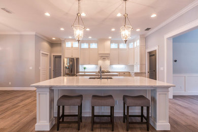 Huge arts and crafts galley porcelain tile eat-in kitchen photo in Tampa with shaker cabinets, white cabinets, quartz countertops, two islands, a single-bowl sink, white backsplash, ceramic backsplash and stainless steel appliances