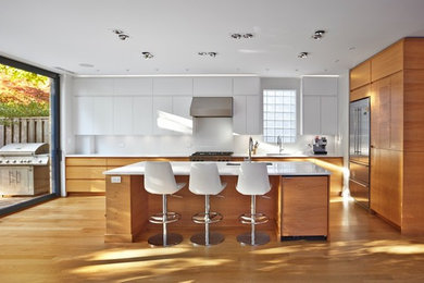 Inspiration for a large contemporary l-shaped light wood floor eat-in kitchen remodel in Toronto with an undermount sink, flat-panel cabinets, white cabinets, tile countertops, white backsplash, subway tile backsplash, stainless steel appliances and an island