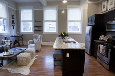 Bild på ett mellanstort vintage vit linjärt vitt kök och matrum, med en undermonterad diskho, luckor med infälld panel, skåp i mörkt trä, granitbänkskiva, rostfria vitvaror, ljust trägolv, en köksö och brunt golv