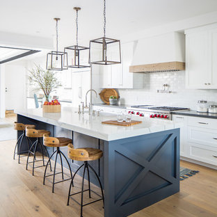 Esempio di una cucina costiera con lavello stile country, ante in stile shaker, ante bianche, paraspruzzi bianco, elettrodomestici da incasso, top nero, parquet chiaro e pavimento beige