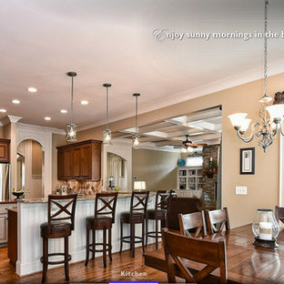 Ispirazione per una grande cucina stile americano con isola, ante con bugna sagomata, ante in legno scuro, top in granito, paraspruzzi beige, paraspruzzi con piastrelle in pietra, elettrodomestici in acciaio inossidabile, lavello sottopiano e pavimento in legno massello medio