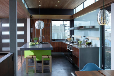 Inspiration for a huge modern galley concrete floor, brown floor and wood ceiling eat-in kitchen remodel in San Francisco with an undermount sink, flat-panel cabinets, medium tone wood cabinets, concrete countertops, blue backsplash, glass sheet backsplash, colored appliances, an island and gray countertops
