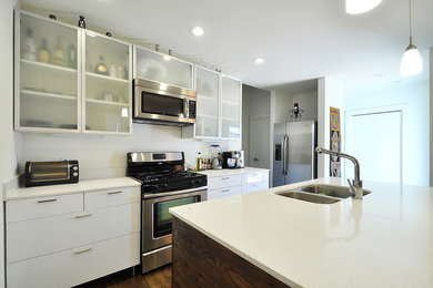 Trendy kitchen photo in Austin with a double-bowl sink, glass-front cabinets, white cabinets and stainless steel appliances