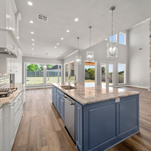 Design ideas for a large traditional l-shaped open plan kitchen in Austin with a single-bowl sink, shaker cabinets, white cabinets, granite benchtops, grey splashback, porcelain splashback, stainless steel appliances, vinyl floors, with island, brown floor and brown benchtop.