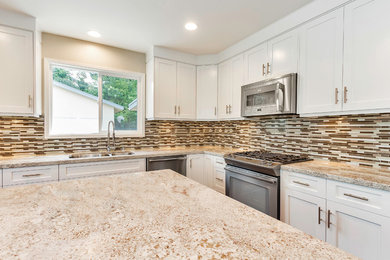 Example of a mid-sized transitional l-shaped medium tone wood floor open concept kitchen design in Orange County with an undermount sink, raised-panel cabinets, white cabinets, granite countertops, brown backsplash, glass tile backsplash, stainless steel appliances and an island