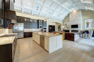 Example of a large classic u-shaped medium tone wood floor and beige floor open concept kitchen design in Austin with an undermount sink, recessed-panel cabinets, dark wood cabinets, granite countertops, multicolored backsplash, matchstick tile backsplash, stainless steel appliances and an island