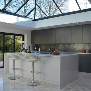 This is an example of a medium sized contemporary l-shaped kitchen in Cambridgeshire with a submerged sink, flat-panel cabinets, an island and beige floors.