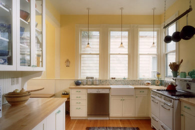 Inspiration for a contemporary medium tone wood floor kitchen remodel in San Francisco with a farmhouse sink, shaker cabinets, white cabinets, wood countertops and no island